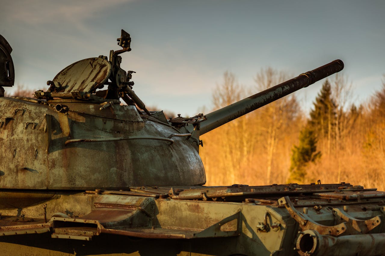 journey-01 A rusted tank set against a forest background in Bosnia, highlighting historic military remnants.