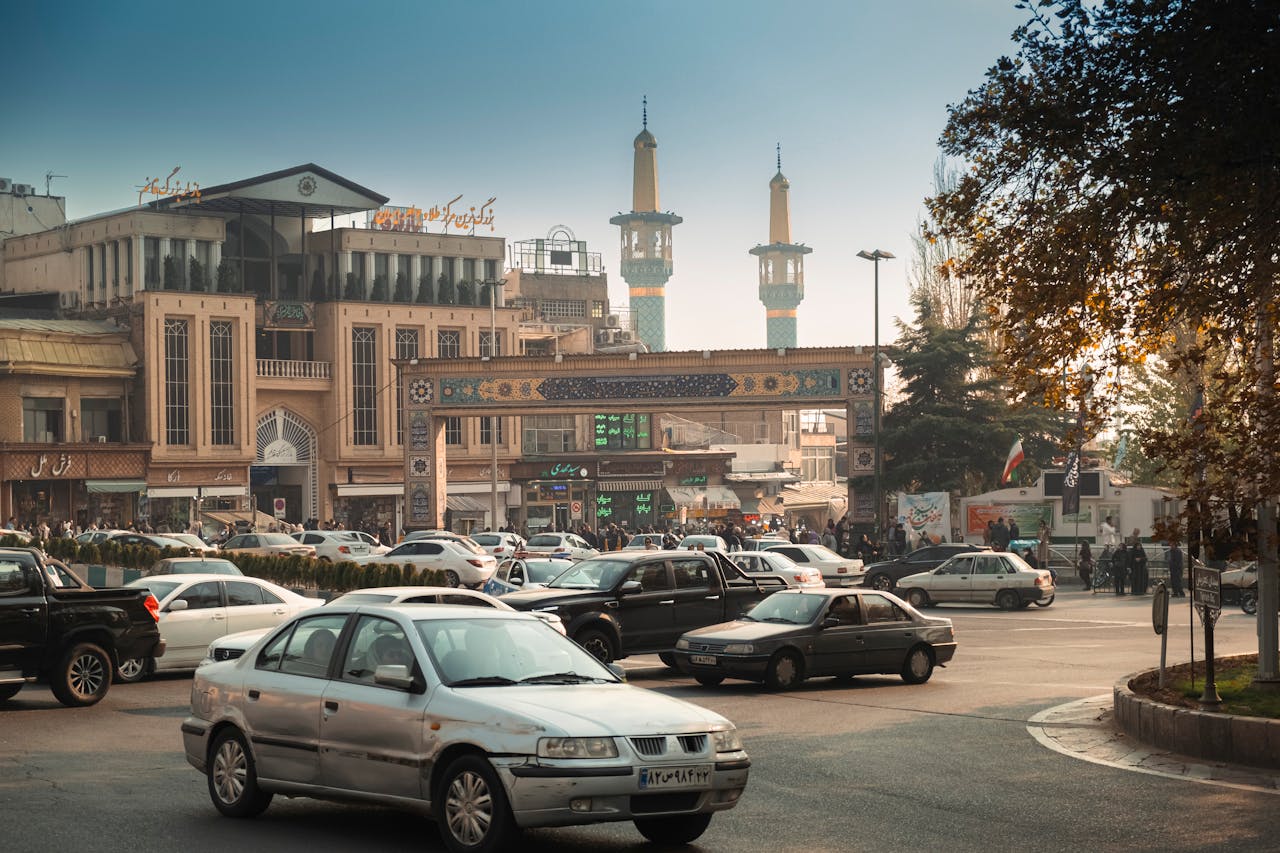 vision Bustling Tehran street scene with cars, mosque minarets, and traditional architecture.