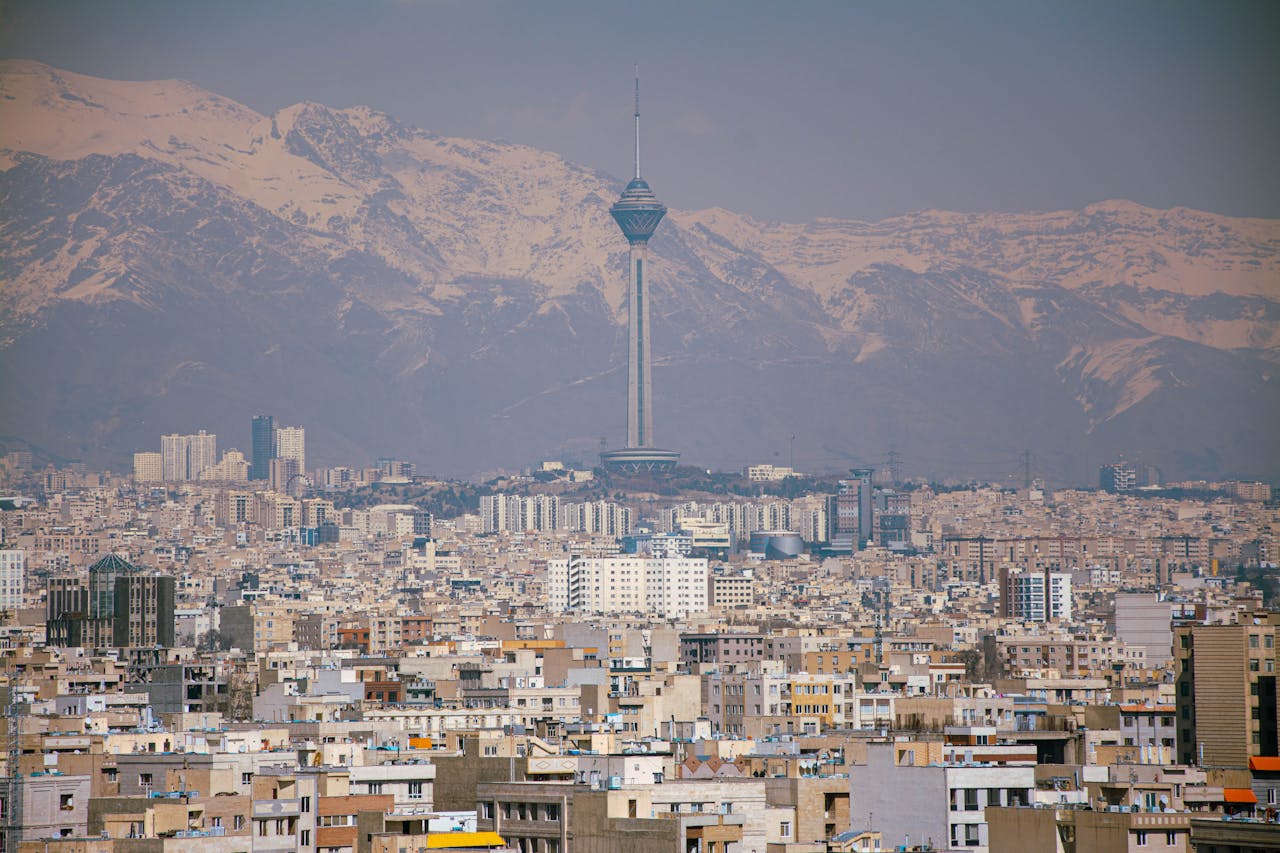 services-04 Aerial view of Tehran featuring Milad Tower against the Alborz Mountains.