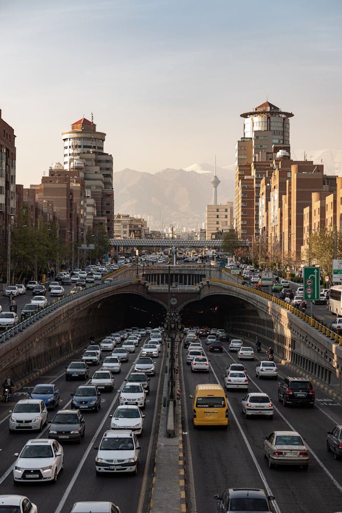gallery-05 Traffic on a busy street in Tehran with Milad Tower and mountains in the background.
