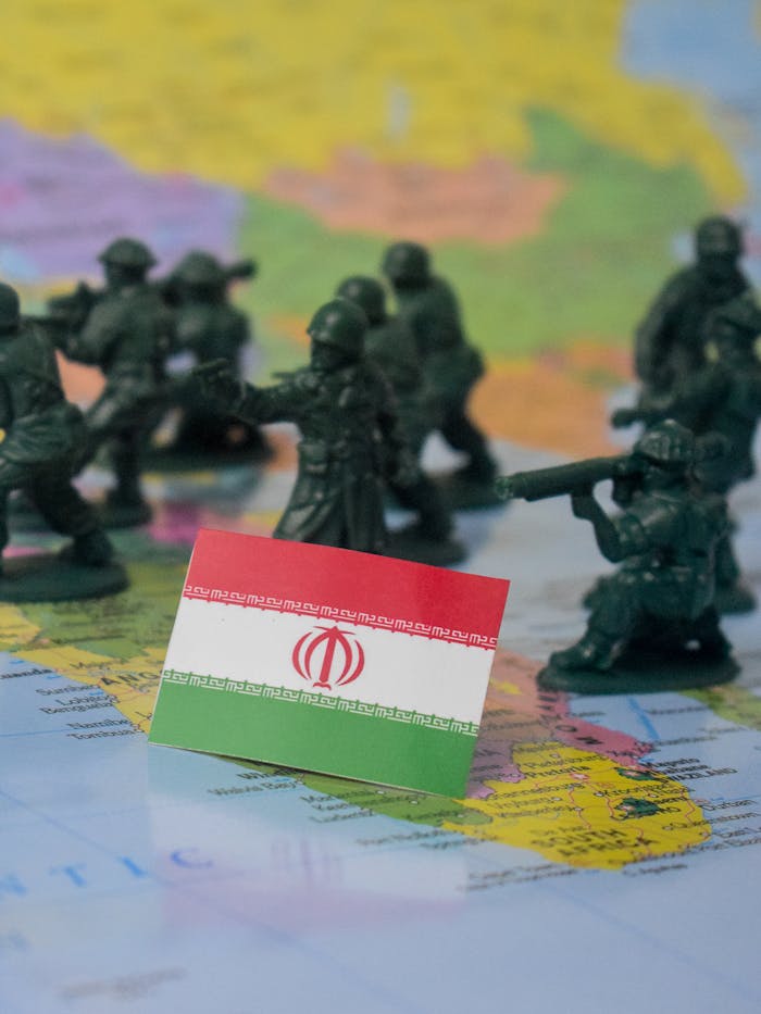 gallery-02 Toy soldiers and Iran flag on a world map symbolizing geopolitical tensions.