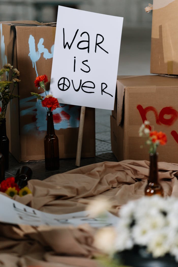 trusted-partner Anti-war protest scene with a "War is Over" sign and flowers in bottles.